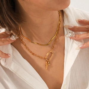 Détail d'un collier multicouche en acier inoxydable doré avec trombones et maille serpent
