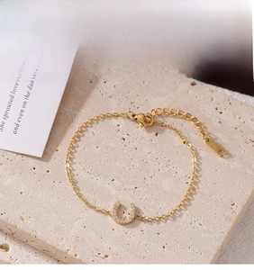 Macro shot of gold horseshoe U-shaped bracelet with pavé cubic zirconia and lobster clasp