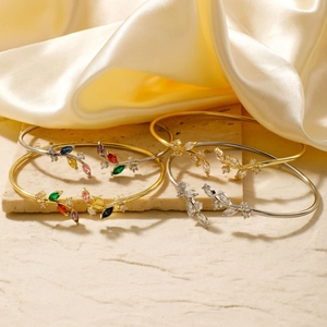 Detailed macro shot of elegant leaf-shaped open bangles with colorful zircon inlays