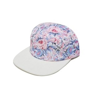 Detail view of 5-panel floral print camp cap with white flat brim and metal side eyelets