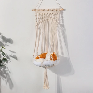 Detail of bohemian hand-woven cotton cat hammock with wood support and plush cushion