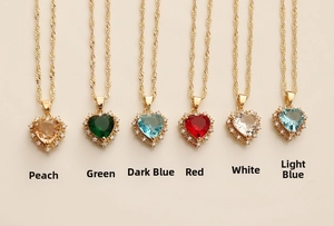 Close-up of heart-shaped zircon necklaces with colorful gemstones and golden rope chains