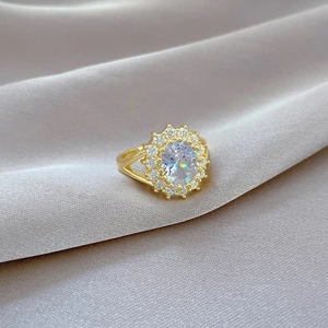 Detailed macro view of gold-tone ring with oval clear gemstone and pavé diamonds