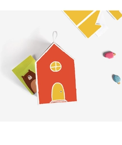 Detail of red house-shaped gift box with yellow roof, bear tag and cute accessories