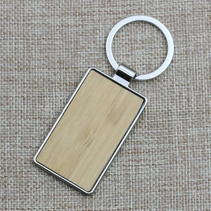 Detailed macro view of rectangular metal keychain with natural bamboo wood insert inlay