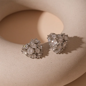 Detail view of silver heart earrings with micro-pave cubic zirconia on ceramic prop
