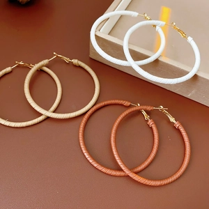 Three pairs of leather-wrapped geometric hoop earrings in white, beige, and brown colors
