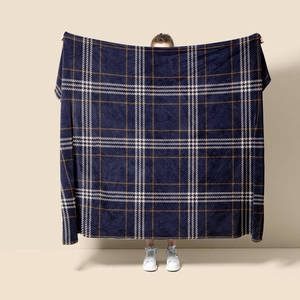 Detail view of thick blue plaid flannel blanket with warm fleece texture for sofa or office