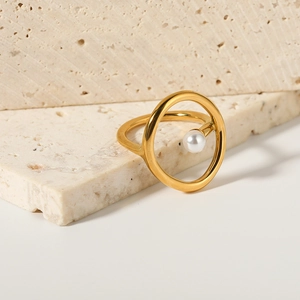 Minimalist 18k gold stainless steel open ring with a round white pearl on travertine