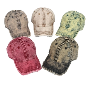 Detail of five colors of vintage washed denim baseball caps with distressed ripped holes