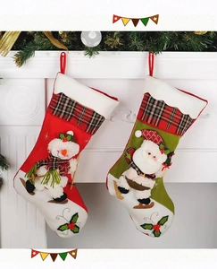 Détail de chaussettes de Noël en tissu avec bonhomme de neige et Père Noël sur cheminée