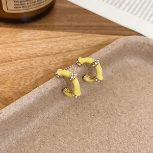Detail of yellow enamel bamboo C-shape earrings with S925 silver needles and crystals
