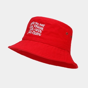 Détail d'un bob en coton rouge avec slogans blancs brodés et œillets de ventilation en métal