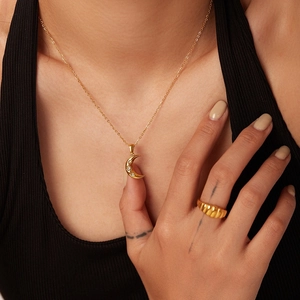 Collier lune en acier inoxydable plaqué or 18 carats avec trois zircons porté par un mannequin