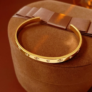 Gros plan du bracelet jonc doré avec zircons brillants et motifs de soleil gravés