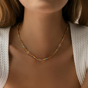 Detail of bohemian choker necklace with colorful beads and gold clover pendants on model