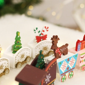 Festive painted wooden Christmas train ornament with reindeer and tree on snow background