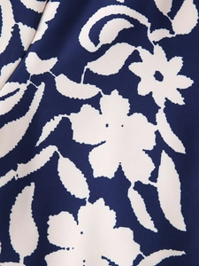 Dettaglio del tessuto blu scuro con stampa floreale bianca e trama del materiale