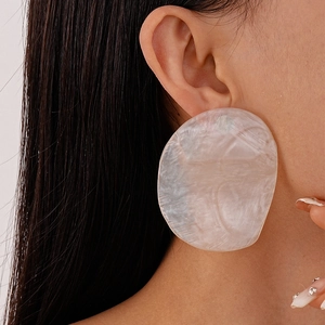Macro shot of oversized irregular pink resin earrings with shell texture on model