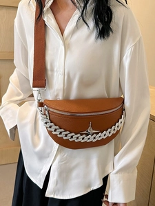 Brown lychee leather crescent chest bag with silver chain worn by a female model