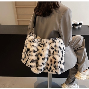 Detail of plush leopard print tote bag texture and metal buckle on the black strap