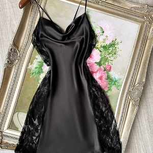 Elegant black satin slip dress with lace trim displayed on a vintage gold frame