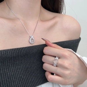 Detail of S925 silver jewelry set with oval pink stone and diamond accents on model