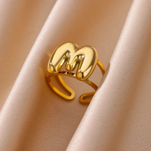 Macro detail of gold bubble letter M ring with adjustable double-layer open band