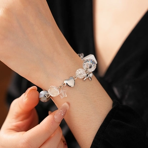 Detail of candy bow star beaded bracelet featuring faceted glass beads on woman's wrist
