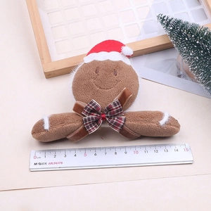 Cute plush gingerbread man hair clip with a red Christmas hat and plaid bow accessory