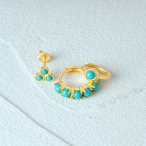 Macro shot of 925 sterling silver turquoise earring set with gold plating finish