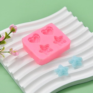 Pink silicone mold featuring heart and star shapes on a decorative white tray