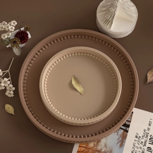 Nesting set of round trays with beaded edge in earthy brown and tan matte finish