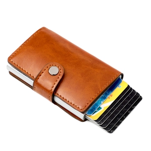 Detail of slim brown leather wallet showing the pop-up aluminum credit card holder mechanism