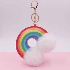 Detail of colorful rainbow faux leather ring with soft white plush pompoms and gold metal clasp