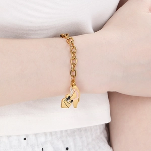 Detailed view of gold pearl chain bracelet with heart-shaped pregnancy pendant on wrist