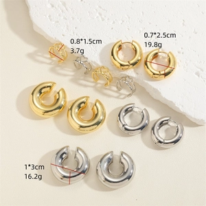 14K gold and silver plated C-shaped cuff earrings set on a minimalist stone background