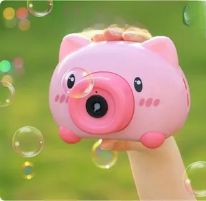 Outdoor close-up of pink pig bubble camera toy spraying colorful bubbles on lawn