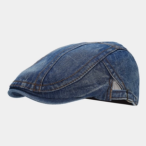 Detail of stone-washed denim ivy cap featuring yellow stitching and metal side buckle