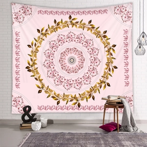 Pink bohemian mandala tapestry with floral patterns hanging on a white brick wall decor