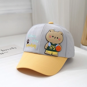 Detail of cotton baby baseball cap featuring cartoon bear embroidery and yellow visor brim