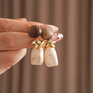 Detail of vintage geometric earrings with wood studs and marble resin pendants