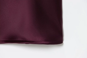 Close-up of wine red satin fabric midi dress showing smooth texture and detailed stitching