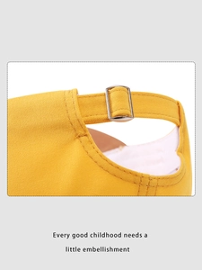 Detail of adjustable metal buckle and stitching on yellow cotton dinosaur baseball cap