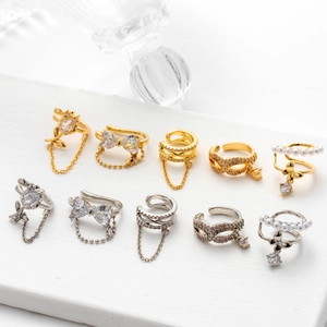 Detail of cubic zirconia butterfly ear cuffs with pearls and tassels in gold and silver