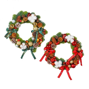 Christmas wreath with pine cones cotton and festive ornaments in red and green