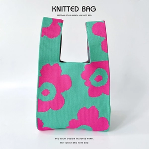 Detail of vibrant flower pattern on green knitted tote bag with textured knit fabric
