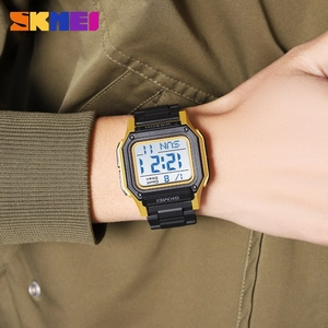 Digital sport watch with gold square case and black rubber strap on model wrist