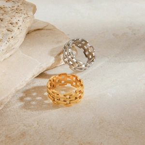 Details der Edelstahlringe mit Webmuster in Gold und Silber auf Naturstein