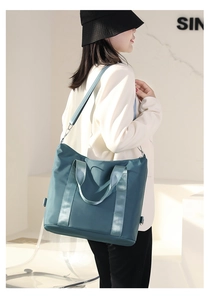 Detail of teal nylon tote bag with reinforced handles and adjustable strap for women